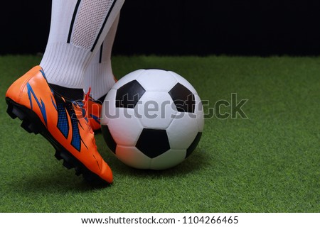 close up legs and feet of soccer player or football player walk on green grass ready to play match.
