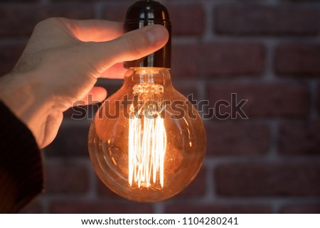 Decorative antique edison style light tungsten bulbs against brick wall background. Close-up.