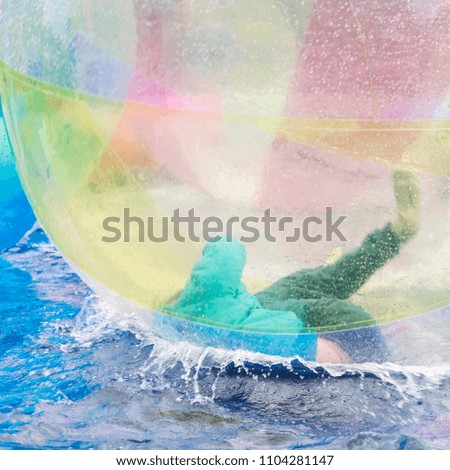 subjug inside a huge plastic transparent ball jumps on the water