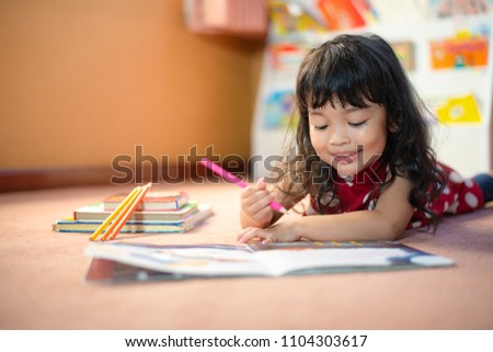 A cute little child Asian girl doing homework and reading a book. Kid enjoy learning with happiness at home. Clever,Education and smart learning concept Royalty-Free Stock Photo #1104303617