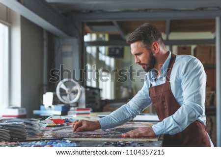 Mature man with mosaic in workshop
