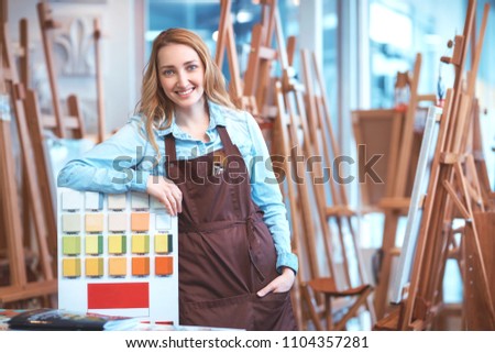 Smiling young woman in an apron in the store