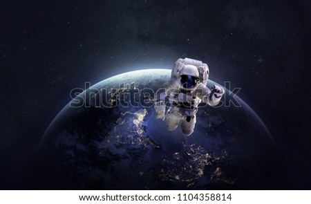 Nightly Earth and astroanut in the outer space. Abstract wallpaper. City lights on planet. Civilization. Elements of this image furnished by NASA