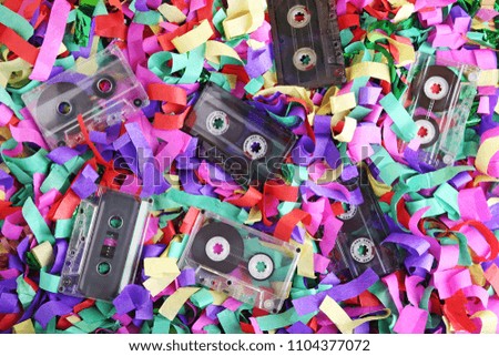 Old cassette tapes on colourful confetti