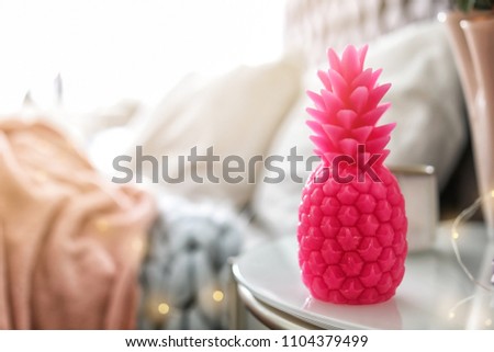Pineapple shaped candle on bedside table in room