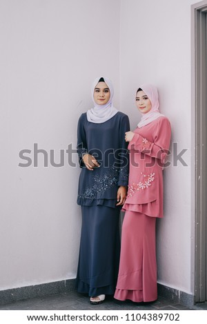 Attractive young Muslim girls wearing baju kurung with hijab.Hijab fashion portraiture.Muslim girl fashion for Kid ul Fitr celebration.Modern muslim girl with hijab.