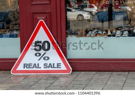 The sign "50% REAL SALE" at the shop window. 