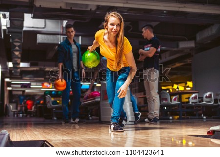 Young woman throwing bowling ball