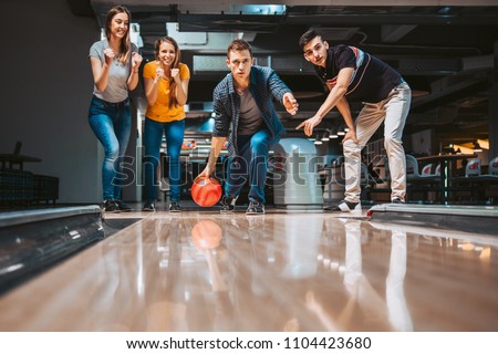 Friends having fun while bowling, happy hour