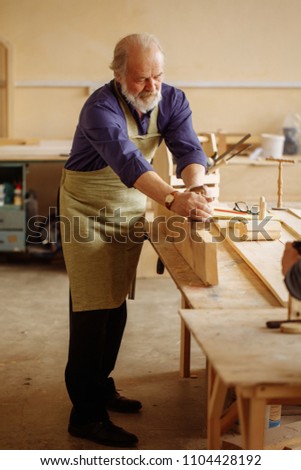 old craftsperson is working with building materials in the workshop