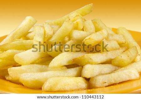 Plate of chips on a gradient background in yellow.