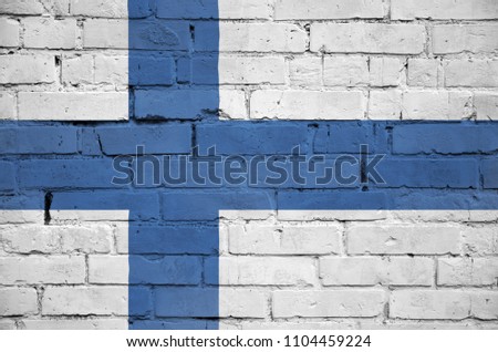 Finland flag is painted onto an old brick wall