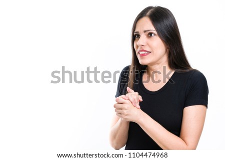 Young beautiful brunette woman with black shirt, anguished, looking away, isolated on white background