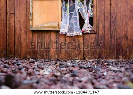 Details of brown wooden house with window and curtains