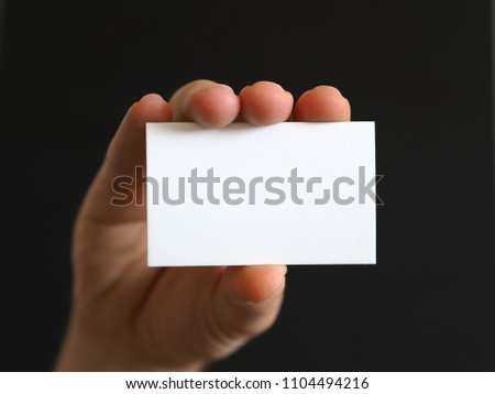 person with a business card in hand or note paper