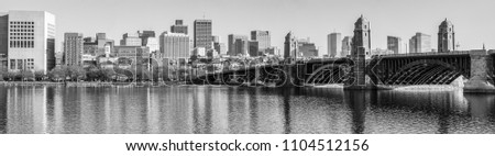Panoramic view of Boston, Massachusetts from the Cambridge side of the Charles River. In black and white with the Longfellow Bridge prominent in the foreground. 