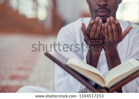 African Muslim Man Making Traditional Prayer To God While Wearing Dishdasha Royalty-Free Stock Photo #1104517253