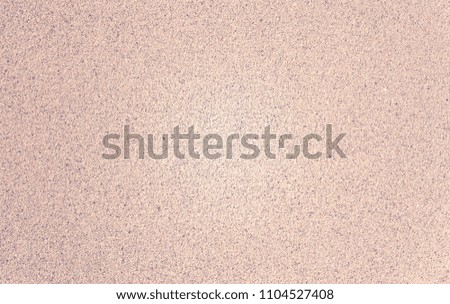 Sea sand, smooth background. Small pellets. Sun Ray