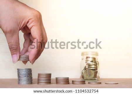 Saving money concept. Finger hold stack coins to arrangement with shown concept of growing business and wealthy,Thai Coins. Royalty-Free Stock Photo #1104532754