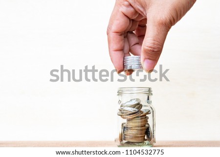 Saving money concept. Finger hold stack coins to arrangement with shown concept of growing business and wealthy,Thai Coins. Royalty-Free Stock Photo #1104532775