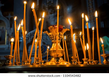 Many burning wax candles in the orthodox church or temple
