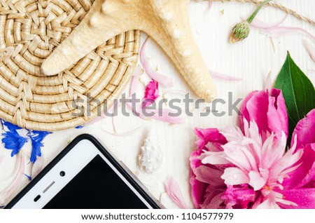 On the white table are the objects. the theme of the summer . gadget , phone is on the table, the sea shells . background on a theme vacation