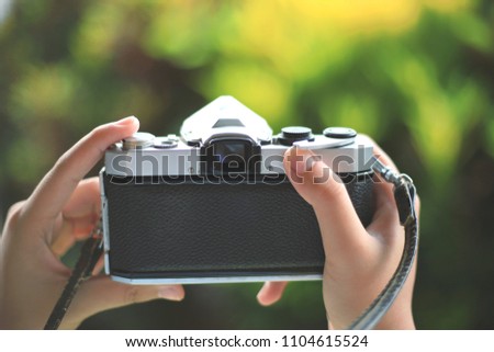 Close-up of a girl's hand using an antique camera taking a picture selective focus and with a very shallow depth of field