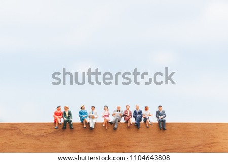 Miniature people: Group of Business people sitting on wooden floor with blue sky background
