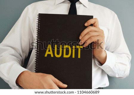 Audit concept. Auditor is holding book.