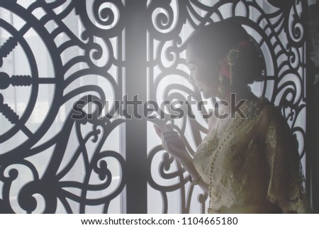 Picture women thai, in thai dress, watching at the window look , black shadow. soft focus.