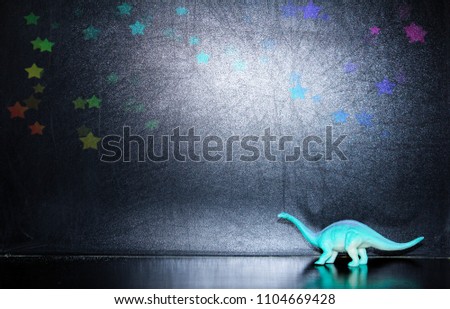 Back to school black  background with blackboard, dinosaur figure and rainbow stars