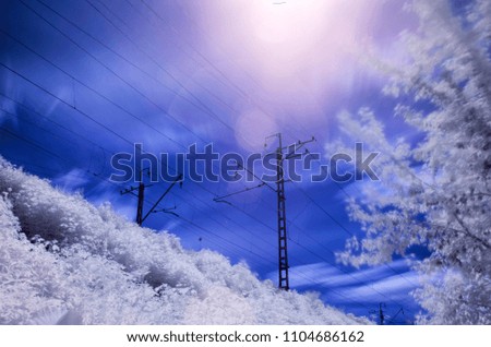 The support of the electric line. Wires against the sky. Infrared photography.