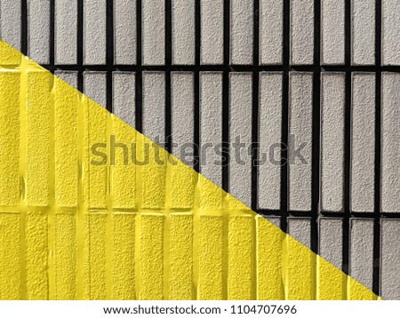 Yellow triangle on a tiled wall