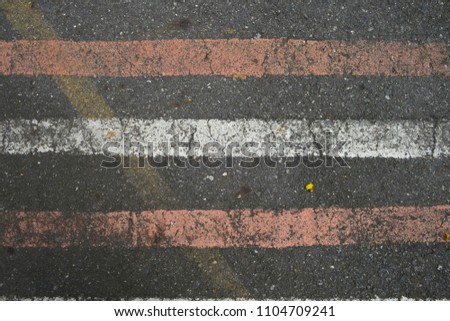 white and red diagonal line on the old and dirty concrete street surface, concrete road. background texture
