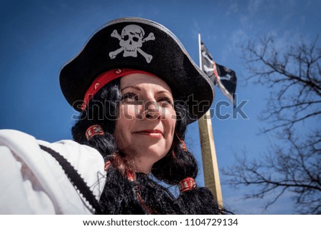 Portrait of a pirate woman  wearing hat and costume on blue sky background