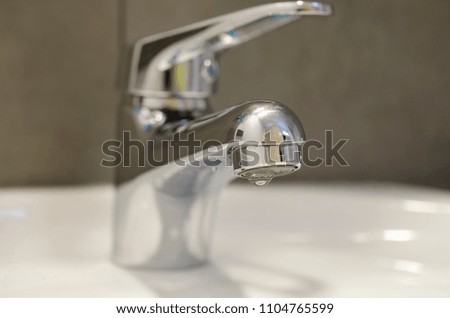 Chrome bathroom faucet.on a white sink in a beautiful granite bathroom.