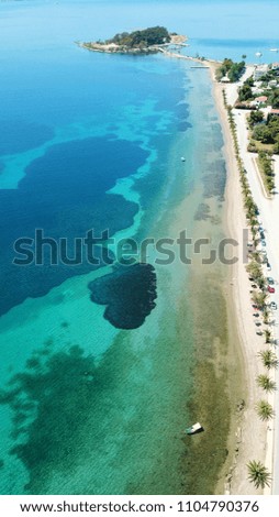 Aerial drone bird's eye view photo of tropical caribbean island forming atoll with small sandy beach and beautiful emerald and sapphire clear waters