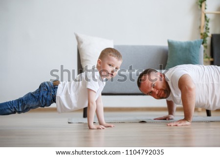 Image of happy dad and son pushing on floor