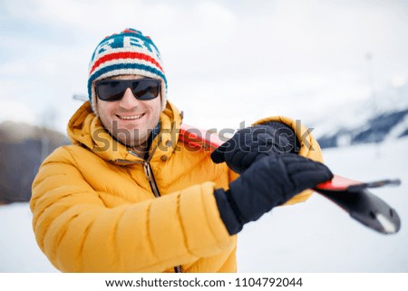 Picture of smiling man with mountain skis