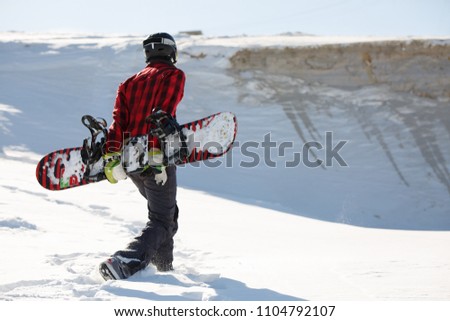 Photo from back of man with snowboard