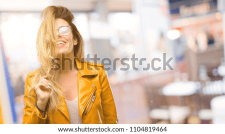 Beautiful young woman confident and happy with a big natural smile laughing, natural expression at restaurant