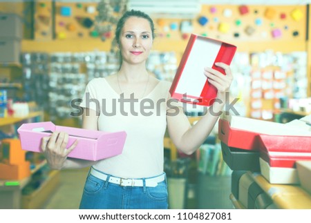Happy adult girl with gift boxes in her hands chooses accessories for gift in store