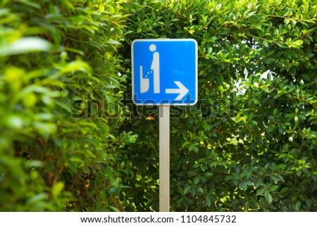 Blue public toilet sign for men with tree on the background