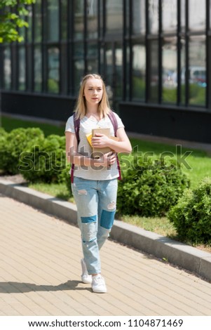 teen student girl with books walking on street