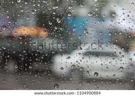 Abstract of drop water on the glass with car on the road, Rainy time.