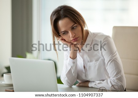 Thoughtful businesswoman thinking searching new ideas looking at laptop, serious employee feeling bored with dull monotonous online office work, employee disinterested in doing boring computer task Royalty-Free Stock Photo #1104907337