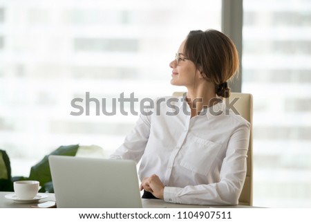 Happy satisfied businesswoman looking away enjoying business success working in office, smiling successful woman boss planning thinking of future goals feeling hopeful motivated about good new job