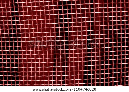 Metal mesh grid pattern in red tone. Abstract background and texture.