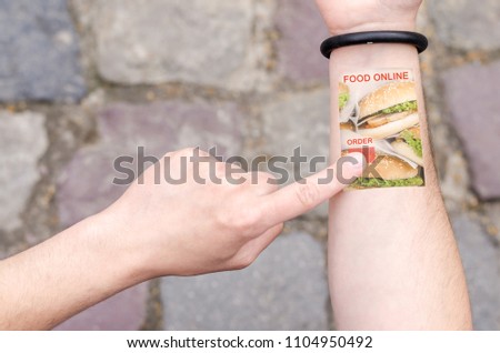 Food Delivery Order Online Grocery Wearable Projection Bracelet Smartphone Mobile Phone on Man Hand Invisible Tech technology Innovations Future Concept  Royalty-Free Stock Photo #1104950492