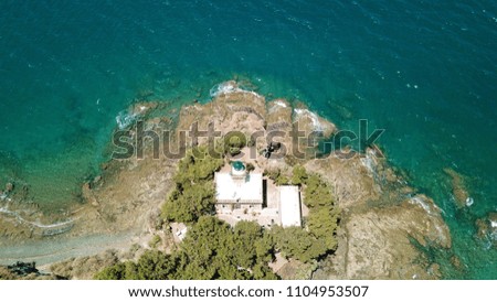 Aerial drone bird's eye view photo of iconic lighthouse built in small vegitated islet